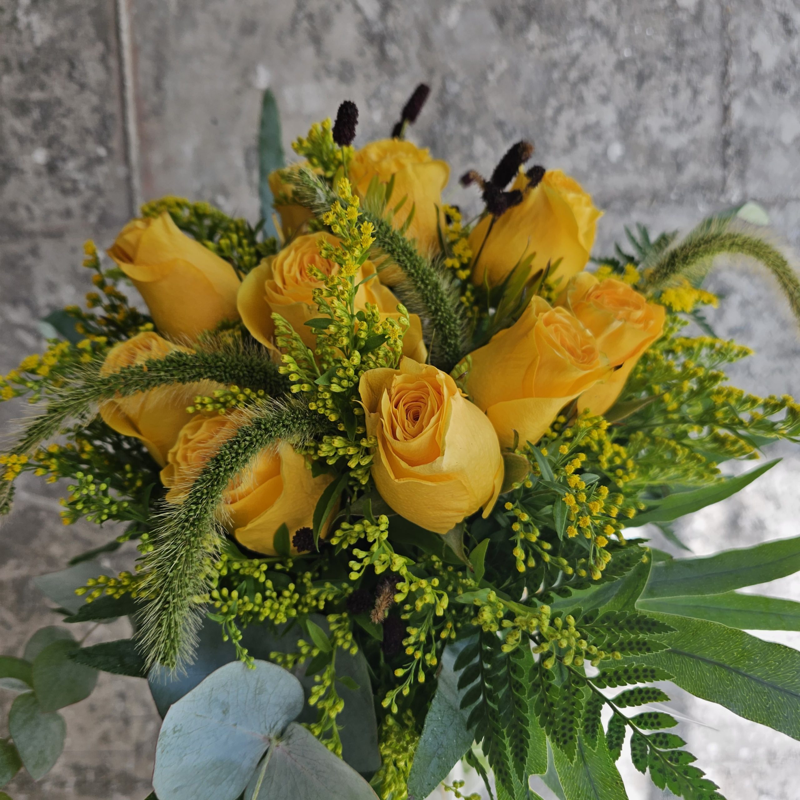 Preciosa composición de rosas amarillas, solidago y espino austríaco, Ramo de flores amarillas símbolo de alegría y esperanza.